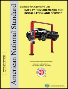 Yellow book titled Standard for Automotive Lifts – Safety Requirements for Installation and Service with black car on red two-post lift in center